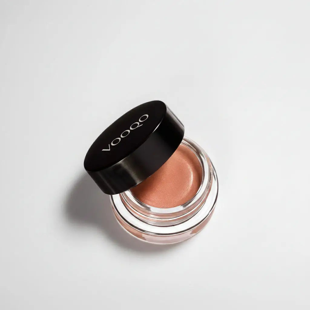 Voodoo cream blush in a clear glass jar with black lid showing peachy-brown creamy eye gel texture